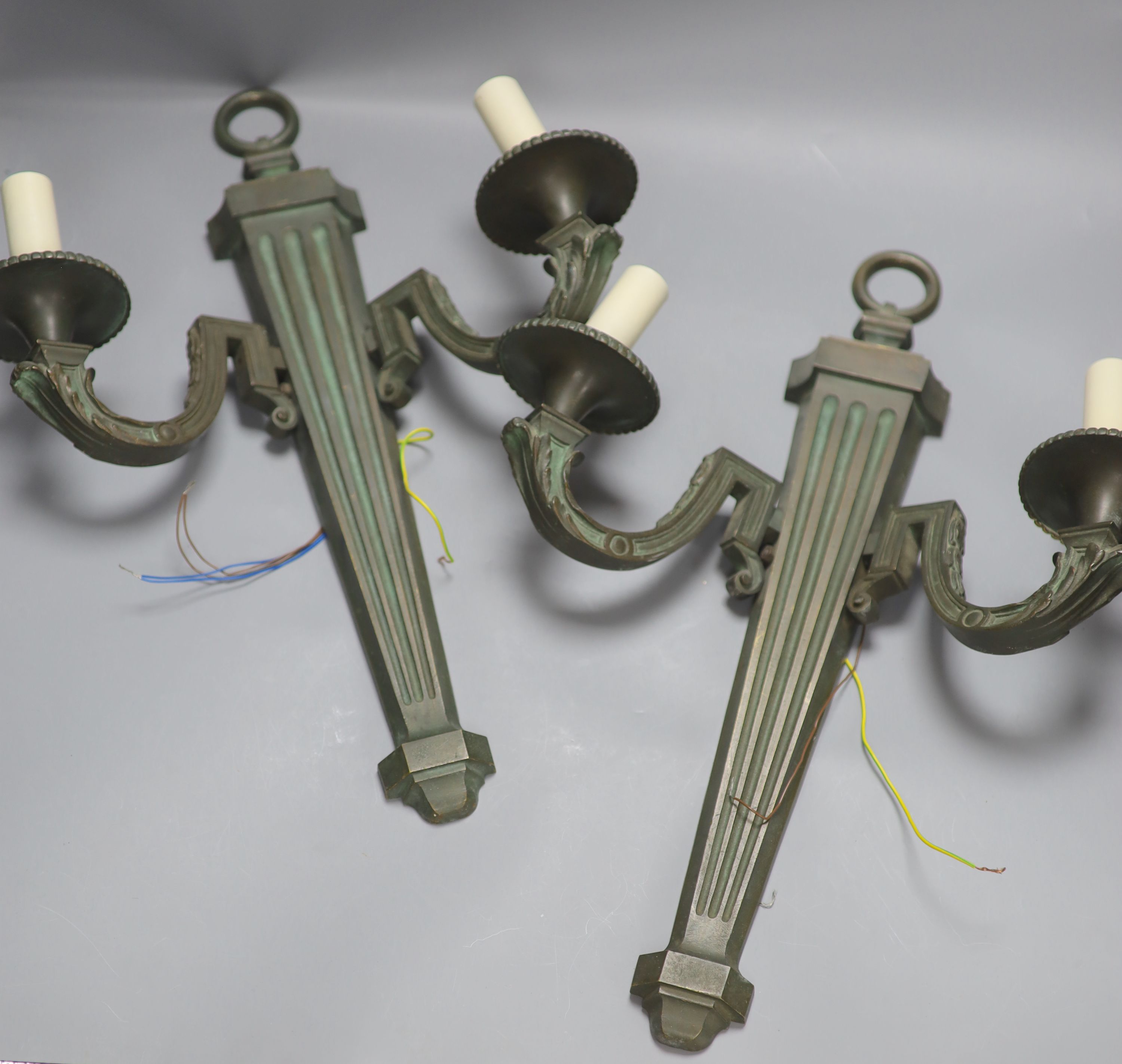 A pair of bronze two branch wall lights, length 52cm